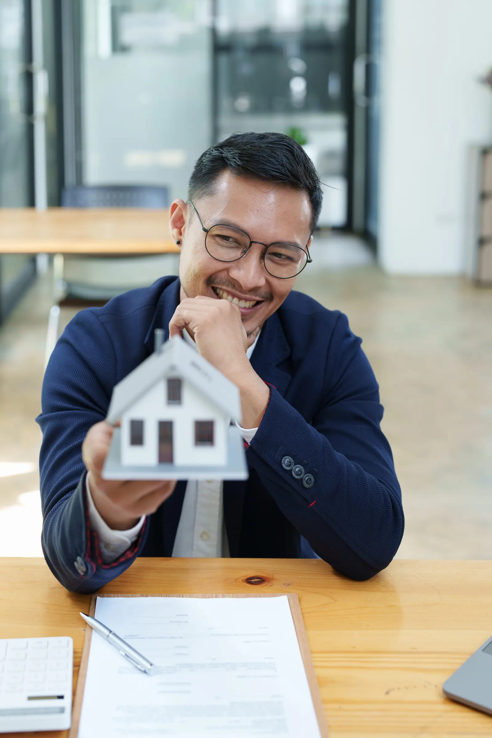 Local business owner holding a model house, reviewing his directory profile